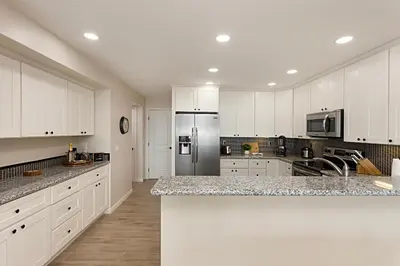 a kitchen with white cabinets and a counter top at Tide and True - SUR129S in Solana Beach