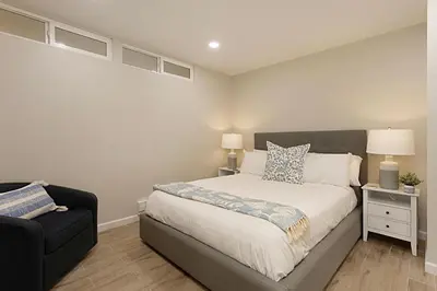 a bedroom with a bed and a black couch at Tide and True - SUR129S in Solana Beach
