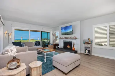 a living room with a couch and a fireplace at Salty Shores - SUR108 in Solana Beach