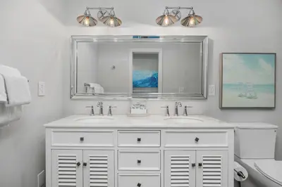 a white bathroom with two sinks and a mirror at Salty Shores - SUR108 in Solana Beach