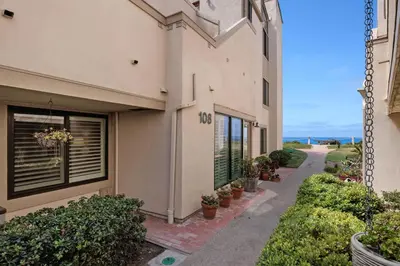 a building with a sidewalk next to a building with plants at Salty Shores - SUR108 in Solana Beach