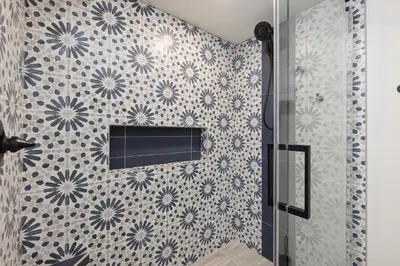 a bathroom with a shower with blue and white tiles at Mermaid's Lookout in San Diego