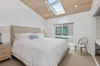 a bedroom with a large bed and a skylight at King of the Beach - SUR79 in Solana Beach