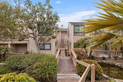 a house with a wooden staircase leading up to a house at King of the Beach - SUR79 in Solana Beach
