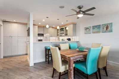 a dining room and kitchen with a wooden table and chairs at Sea Gem - SBTC119 in Solana Beach