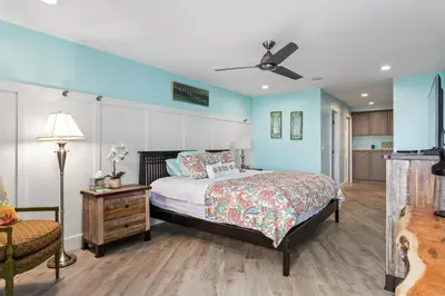 a bedroom with blue walls and a bed and a chair at Sea Gem - SBTC119 in Solana Beach