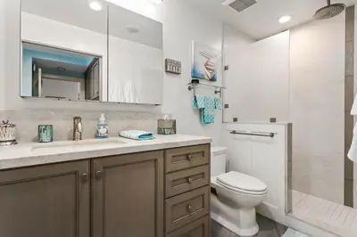 a bathroom with a toilet and a sink and a mirror at Sea Gem - SBTC119 in Solana Beach