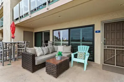 a living room with a couch and a chair on a patio at Sea Gem - SBTC119 in Solana Beach