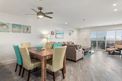 a dining room and living room with a table and chairs at Sea Gem - SBTC119 in Solana Beach