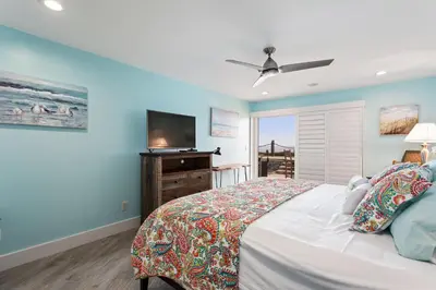 a bedroom with a bed and a flat screen tv at Sea Gem - SBTC119 in Solana Beach