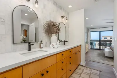 a bathroom with a sink and two mirrors at Ocean Whisper - SBTC238 in Solana Beach