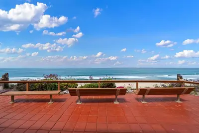 two benches sitting on a patio looking at the ocean at Ocean Whisper - SBTC238 in Solana Beach