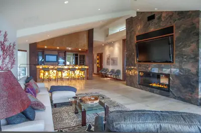 a living room with a large stone wall with a fireplace at Enchanting Oasis - SONG72 in Solana Beach