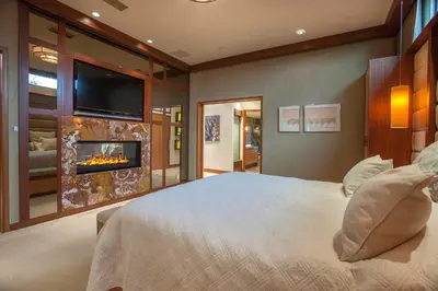a bedroom with a bed with a fireplace and a tv at Enchanting Oasis - SONG72 in Solana Beach