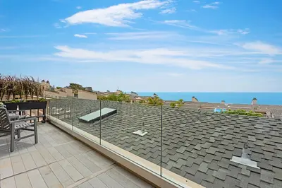 a roof with a bench and the ocean in the background at Coastal Retreat- SUR33 in Solana Beach