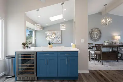 a kitchen with blue cabinets and a dining room at Coastal Retreat- SUR33 in Solana Beach