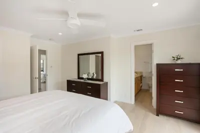a white bedroom with a large bed and a dresser at Pacific Bliss - DMBC767 in Solana Beach