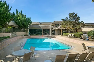 a swimming pool with chairs and a table and a house at Pacific Bliss - DMBC767 in Solana Beach