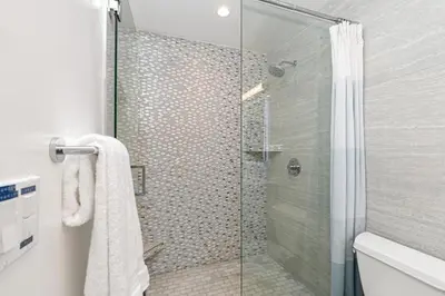 a bathroom with a shower with a glass door at Fairway Haven - CB2507 in Carlsbad