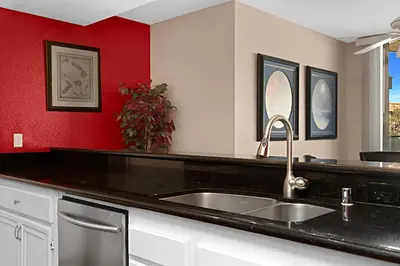 a kitchen with a sink and a red wall at Sea Den - DMST45 in Solana Beach