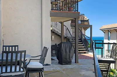 a patio with two chairs and a table and stairs at Sea Den - DMST45 in Solana Beach