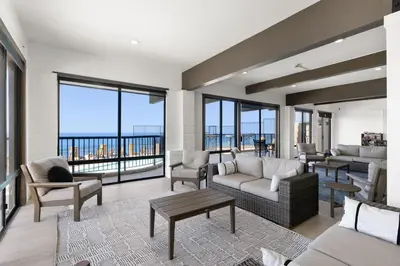 a living room with a couch and chairs and windows at Sea Den - DMST45 in Solana Beach