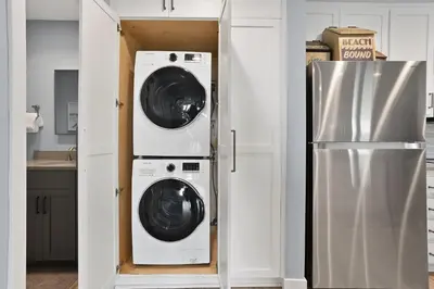 a kitchen with a washer and dryer next to a refrigerator at Aqua Horizon - SBTC112 in Solana Beach