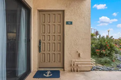 a door to a house with an anchor rug in front at Aqua Horizon - SBTC112 in Solana Beach