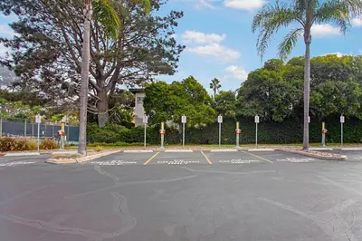 an empty parking lot with trees and palm trees at Villa del Pacifico - SONG20 in Solana Beach