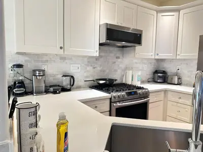 a kitchen with white cabinets and a stove top oven at Close to Irvine IVC&UCI gate community2b &3b house more than 30nights in Irvine