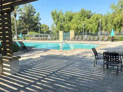 a swimming pool with two chairs and a table at Close to Irvine IVC&UCI gate community2b &3b house more than 30nights in Irvine