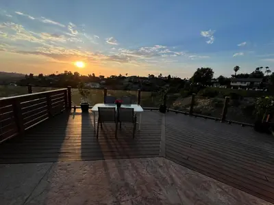 a table and chairs on a deck with the sunset at Serenity - Amazing Views & Modern Charm in La Mesa