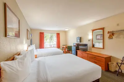 a hotel room with two beds and a television at Hotel Avenida, San Clemente Beach in San Clemente
