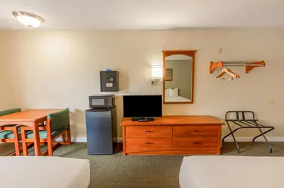a hotel room with a desk and a tv and a table at Hotel Avenida, San Clemente Beach in San Clemente