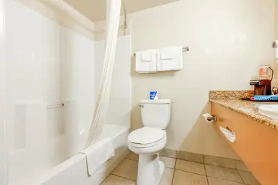 a bathroom with a toilet and a shower and a sink at Hotel Avenida, San Clemente Beach in San Clemente