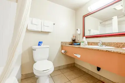 a bathroom with a toilet and a sink and a mirror at Hotel Avenida, San Clemente Beach in San Clemente