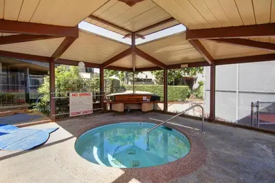 an outdoor pool with a pavilion with a pool table at Beachy Keen & Cleen - DMBC148S in Solana Beach