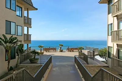 a walkway between two buildings with a view of the ocean at Beachy Keen & Cleen - DMBC148S in Solana Beach
