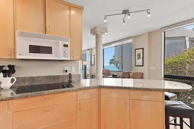 a kitchen with wooden cabinets and a counter top at SandyToes-SunKist Nose-CHAT2 in Solana Beach