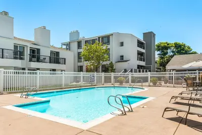 a swimming pool with chairs and a fence at SandyToes-SunKist Nose-CHAT2 in Solana Beach