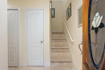 a hallway with a white door and stairs at Dolphin View - SUR43 in Solana Beach