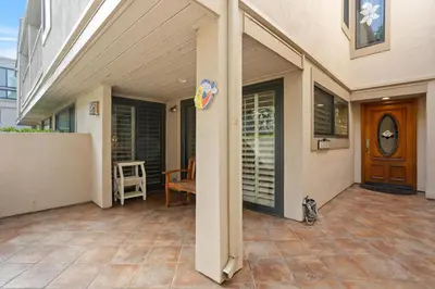 a front porch of a house with a table and a chair at Dolphin View - SUR43 in Solana Beach
