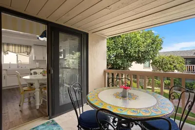 a patio with a table and chairs on a balcony at Dolphin View - SUR43 in Solana Beach