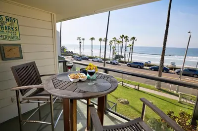 a table on a balcony with a view of the beach at Coastal Luxury with Panoramic Ocean View in Oceanside