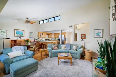 a living room with blue couches and a kitchen at Coastal Luxury with Panoramic Ocean View in Oceanside