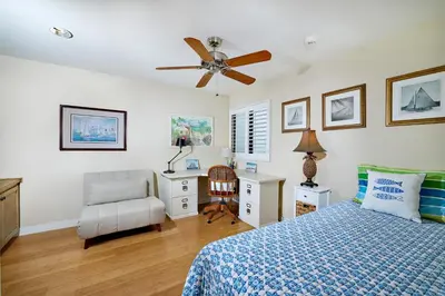 a bedroom with a bed and a desk and a ceiling fan at Coastal Luxury with Panoramic Ocean View in Oceanside