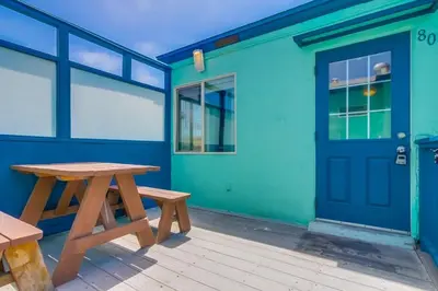 a picnic table in front of a building with a blue door at Manhattan Shores 1A in San Diego