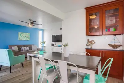 a dining room and living room with a table and chairs at Manhattan Shores 5 in San Diego
