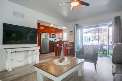 a living room with a table and a kitchen at Manhattan Shores 5 in San Diego