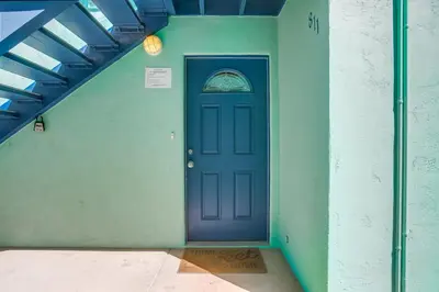 a blue door in a green wall with a window at Manhattan Shores 5 in San Diego